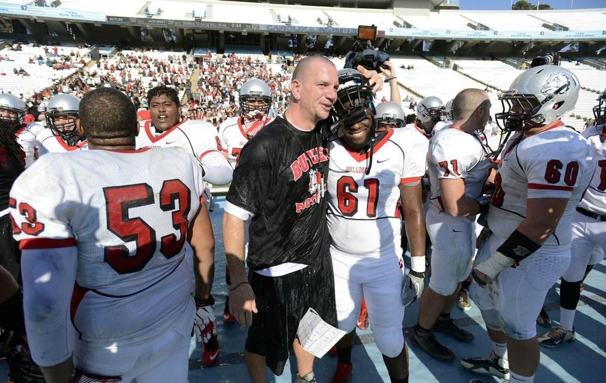 Butler football coach Brian Hales hugs Jacobie Gore (61) as the team starts to celebrate their victory over Jack Britt in the N.C. 4AA football championship game at Kenan Stadium in Chapel Hill on December 1, 2012. Butler won 56-28. David T. Foster III-dtfoster@charlotteobserver.com