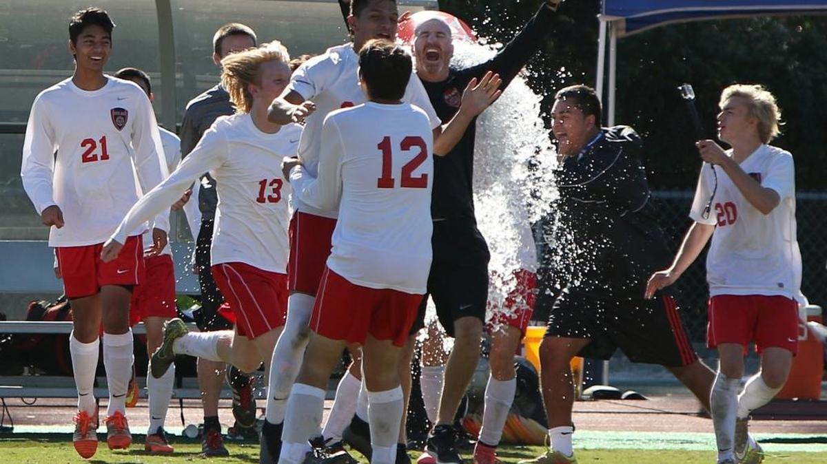 Head soccer coach Eric White, center, is doused with a Gatorade bath as the South Mecklenburg soccer team wins the state championship last year against Wilmington Laney LEE DEMPSEY