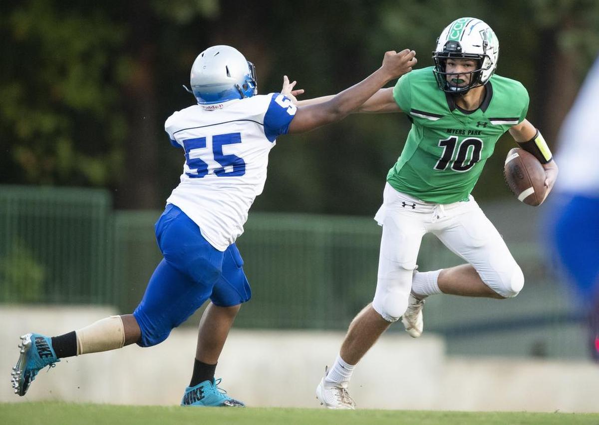 Myers Park sophomore quarterback Drake Maye, right, tries to avoid a Garinger defender in the first quarter of Friday’s Southwestern 4A game at Myers Park. Maye and the Mustangs won 48-7.