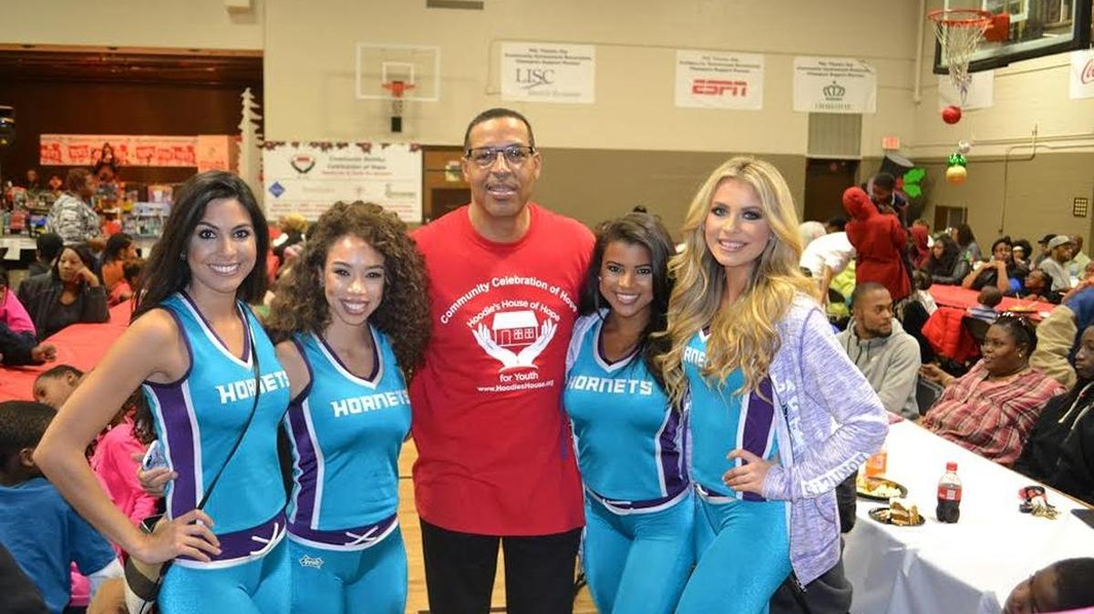 Hoodies House of Hope tournament organizer Jeff Hood poses with members of the Charlotte Hornets cheerleaders, the Honeybees, during a community event Sunday to kick off the basketball tournament