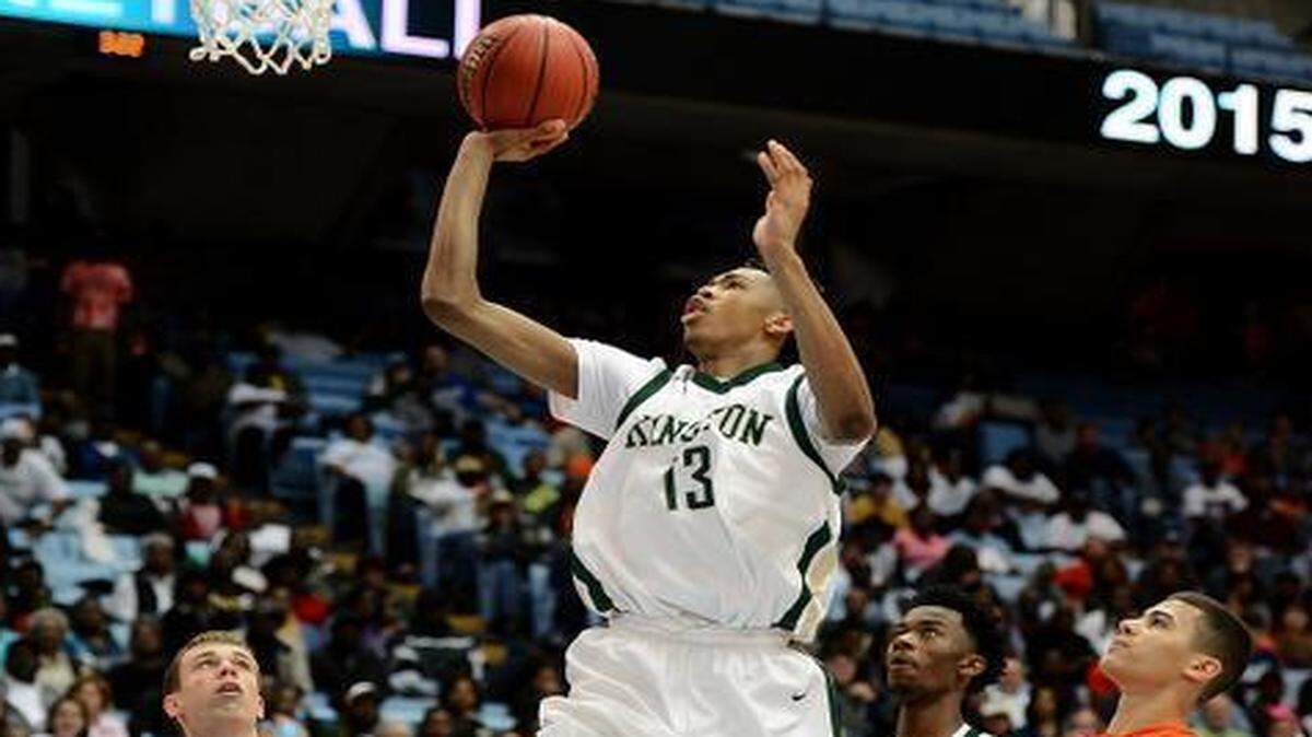 
Kinston's Brandon Ingram (13) drives into the lane for a basket as East Lincoln defenders Sage Surratt (11) and Connor Ashley (10) look on during the NCHSAA 2A State Championship game at the Dean E. Smith Center in Chapel Hill, NC on Saturday March 14, 2015. Kinston defeated East Lincoln 60-43. 
