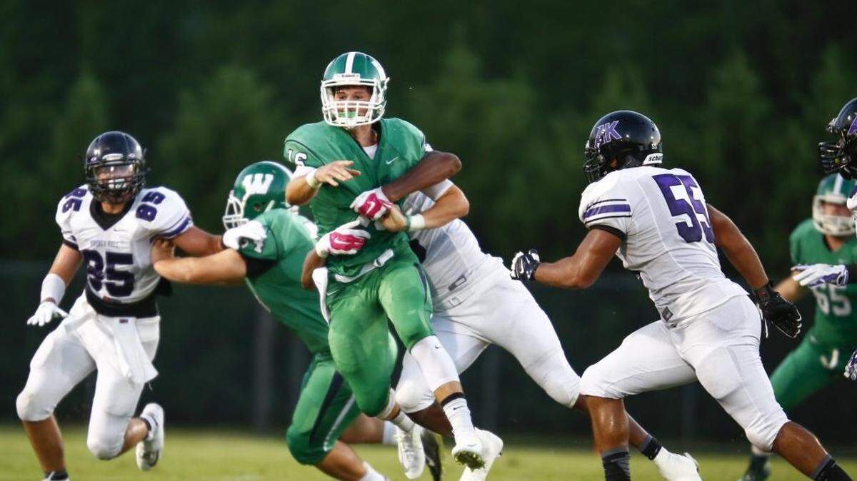 
Weddington quarterback Grayson Willingham (16) gets off a pass while being tackled by an Ardrey Kell defender during a prep football game Friday, Aug. 21, 2015 at Weddington High School in Matthews. 
