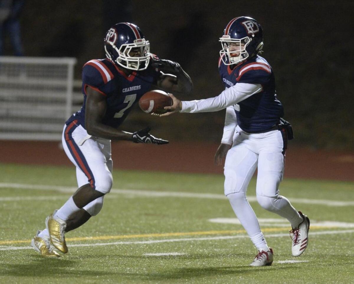Providence Day's Cody Cater (right) hands off to Osita Ekwonu during a game last season. Ekwonu is climbing the recruiting charts this month.