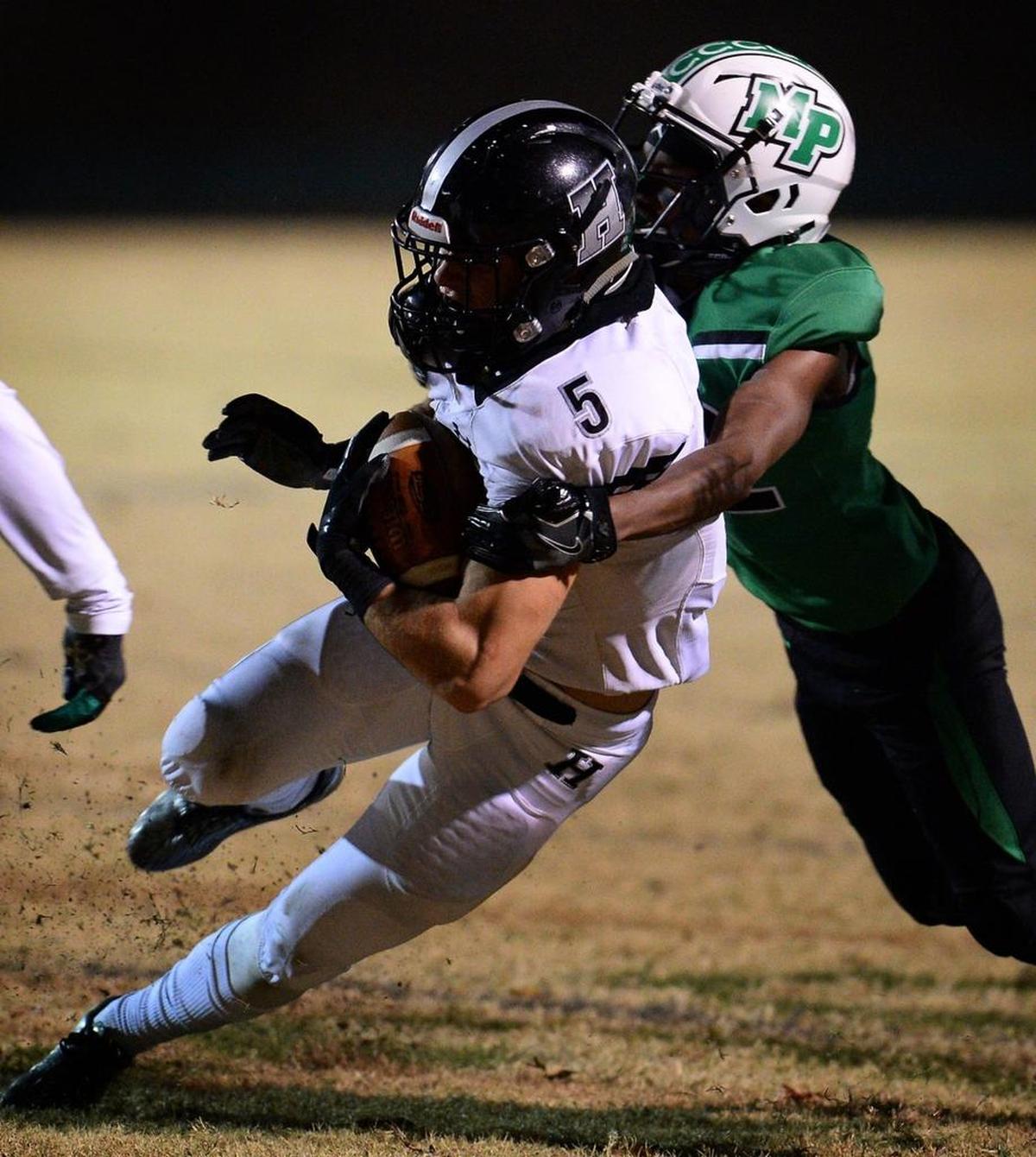 Hough wide receiver Nolan Groulx, left, fights for yardage as Myers Park defensive back Tre Bly, right, looks to make the tackle during first-half action of N.C. 4AA high school football quarterfinals action at Myers Park High School on Friday, Nov. 24, 2017.