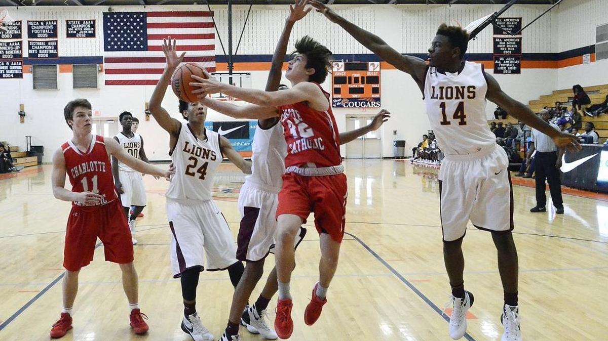 Charlotte Catholic sophomore forward #32 Nick Scibelli drives to the basket late in the second half against West Charlotte #24 Isayah Johnson and #14 Deangelo Epps. Catholic defeated West Charlotte 66-46 during the first game on Saturday Dec. 5, 2015 at the Southeast National Hoops Festival at Vance High School. The teams play a rematch in a third round playoff game Saturday at Catholic