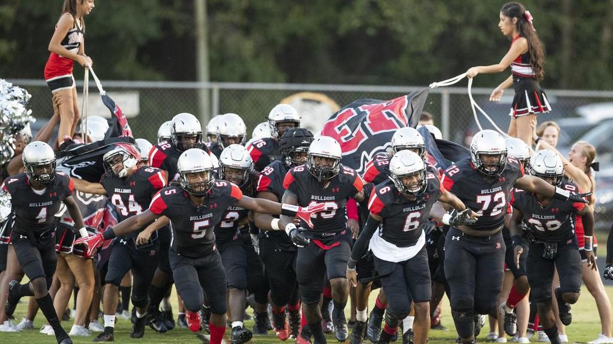 The Butler Bulldogs led by Keyon Lesane (5) and Jaden Clark (6) take the field to face Myers Park at a prep football game at Butler High School Friday, October 5, 2018 in Matthews, NC. Photo by JASON E. MICZEK - Special to the Observer
