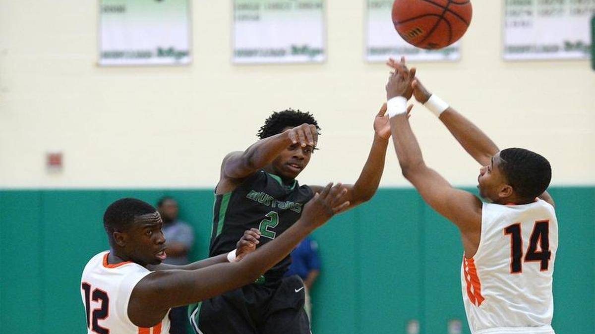 Myers Park's Kevin Alford, center, is forced to pass out of a double team by Rocky River's Anthony Salley III, left and Marcus Evans, right, during the Southwestern 4A tournament at Myers Park High School on Tuesday, February 14, 2017.
