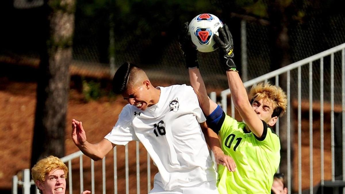 Cardinal Gibbons’ goalkeeper Michael Burns (01) makes a save as Hough’s Pablo Garza (16) crashes into him. The Cardinal Gibbons Crusaders beat the Hough Huskies 2-1 in the NCHSAA 4A mens soccer championship game, November 18, 2017 in Raleigh.