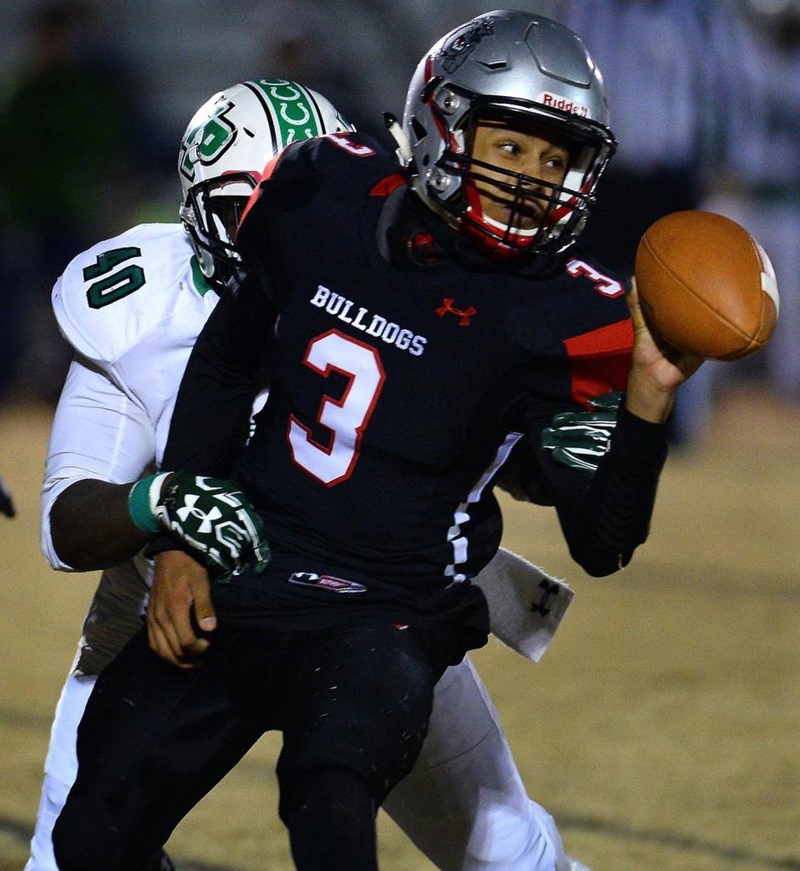 Butler Bulldogs quarterback Christian Peters attempts to pitch the ball to a teammate as he is hit by defensive lineman Deon Caldwell during first quarter action on Friday, November 17, 2017 at Butler High School.