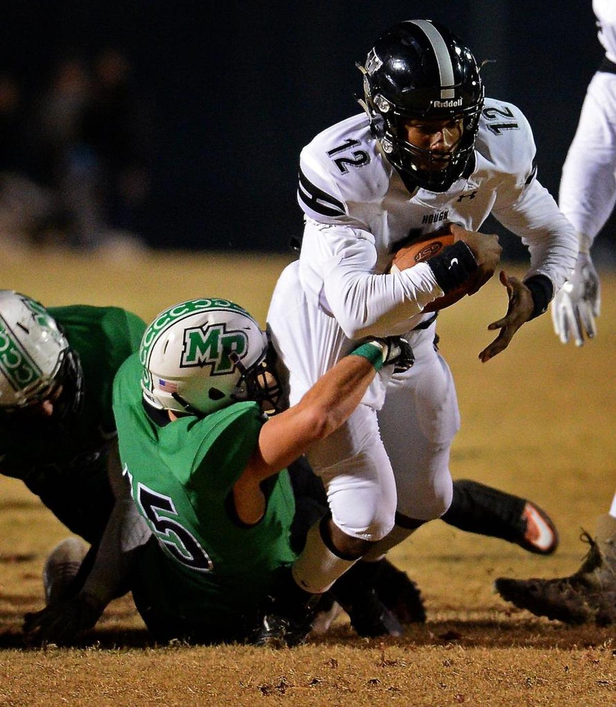 Hough quarterback Kennique Bonner-Steward dives forward for yardage as a Myers Park defender looks to make the tackle during first-half action of N.C. 4AA high school football quarterfinals action at Myers Park High School on Friday, Nov. 24, 2017.