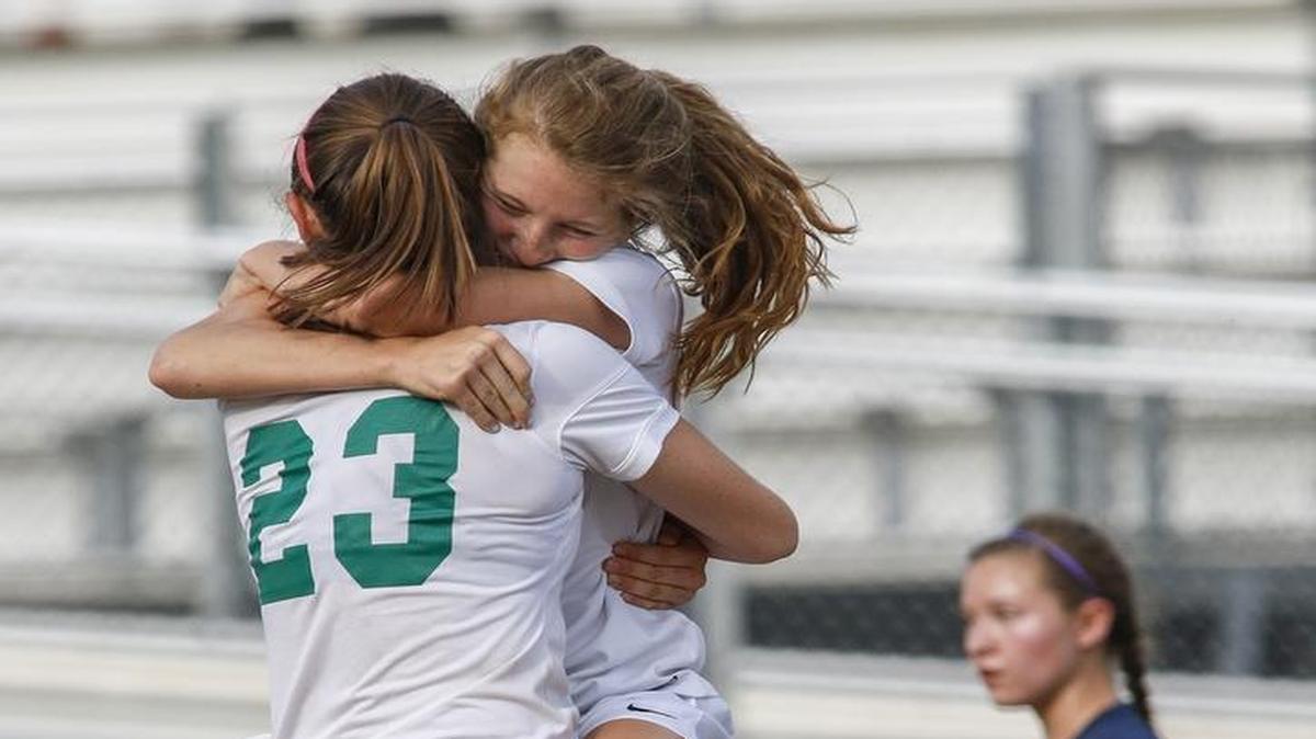 Myers Park forward Laughlin Ryan, right, hugs teammate Kendall Edwards after Ryan scored the first goal against T.C. Roberson in the NCHSAA 4A soccer playoffs in Charlotte on Wednesday.