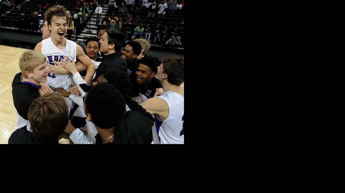
Ardrey Kell's Steven Santa-Ana (22) is mobbed by his teammates following his game winning 3-point shot in the closing seconds against West Charlotte. Ardrey Kell defeated West Charlotte 52-50 to win the NCHSAA 4A boys regional championship game at Lawrence Joel Veterans Memorial Coliseum in Winston-Salem, Saturday, March 7, 2015.

