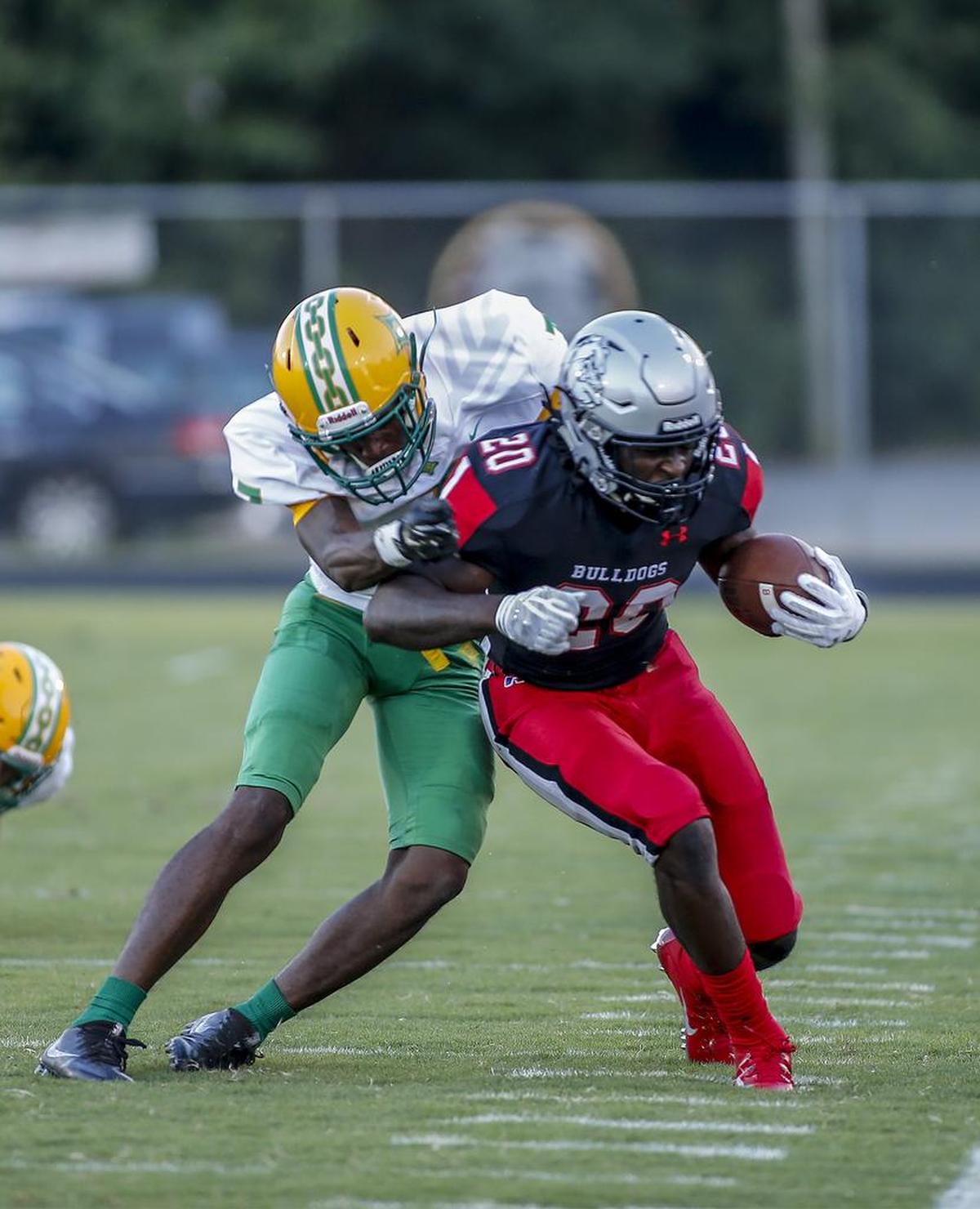 Butler running back Jamal Worthy (20) fights for extra yards against Richmond cornerback Dj Stephens in the first half of Friday’s high school football game in Matthews. Richmond Senior rallied to win 30-19 in the 4A matchup.