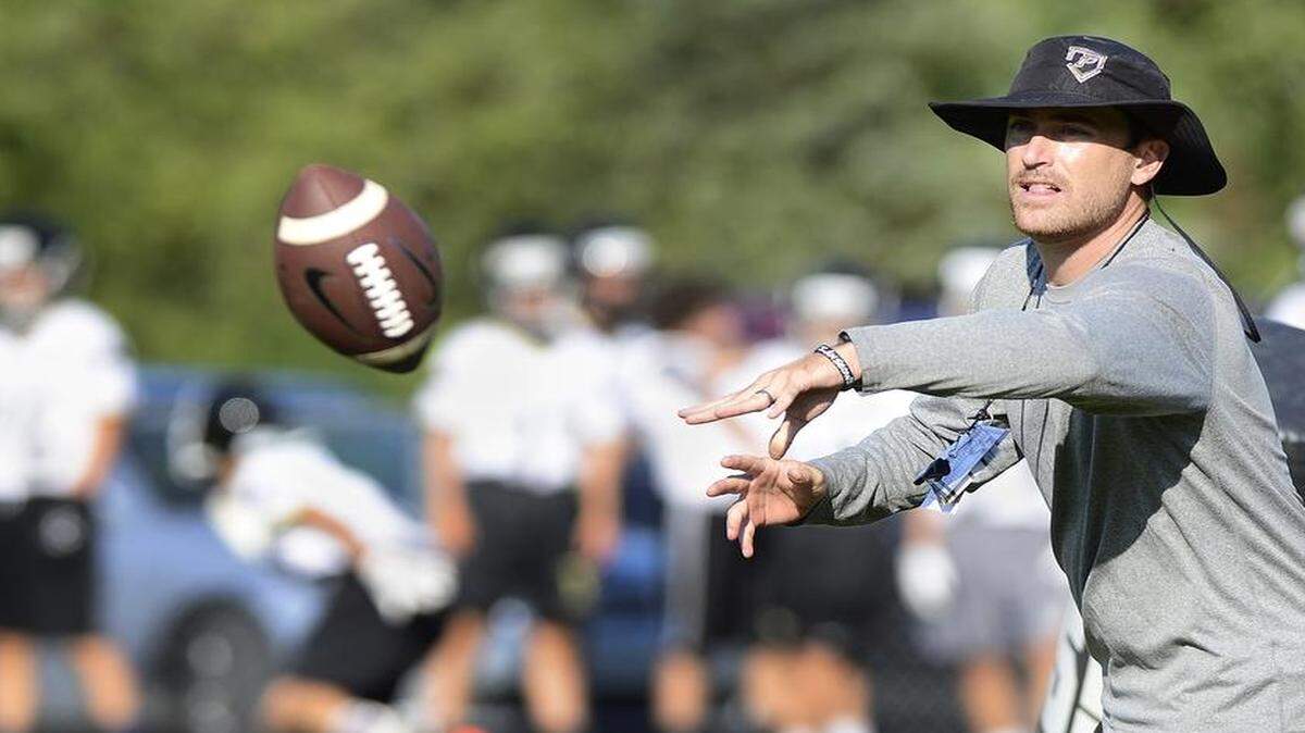 
Providence, No. 15 in the Sweet 16, has a new football coach, Brad Bowles, and a wealth of talent as they try to back up last season's N.C. 4AA quarterfinal appearance. Bowles flips the ball to a player during practice. The Panthers held practice Saturday, Aug. 1, 2015. 
