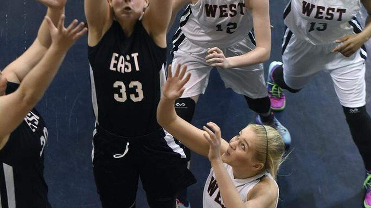 The East's Carol-Anne Obusek (33) of Grace Christian battles for a rebound with the West's Celine Ives (33), Erin Whalen (12), both of Providence Day, and Kerstie Phills (13) of Charlotte Christian during Saturday’s N.C. Private School All-Star game. The West won 93-75.