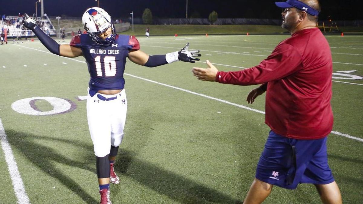 
Mallard Creek's Larry Matkins (10) celebrates with head coach Mike Palmieri after the Maverick's beat Butler during a prep football game at Mallard Creek High School Friday, August 28, 2015 in Charlotte.
