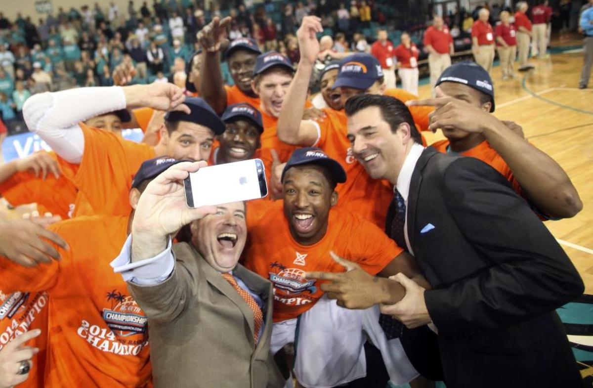 Members of the Coastal Carolina men's basketball team pose for a "selfie" with ESPN announcers Roy Philpot, left, and ESPN director of recruiting Paul Biancardi after an NCAA college basketball game against Winthrop in Conway, S.C., Sunday, March 9, 2014. (AP Photo/Willis Glassgow)