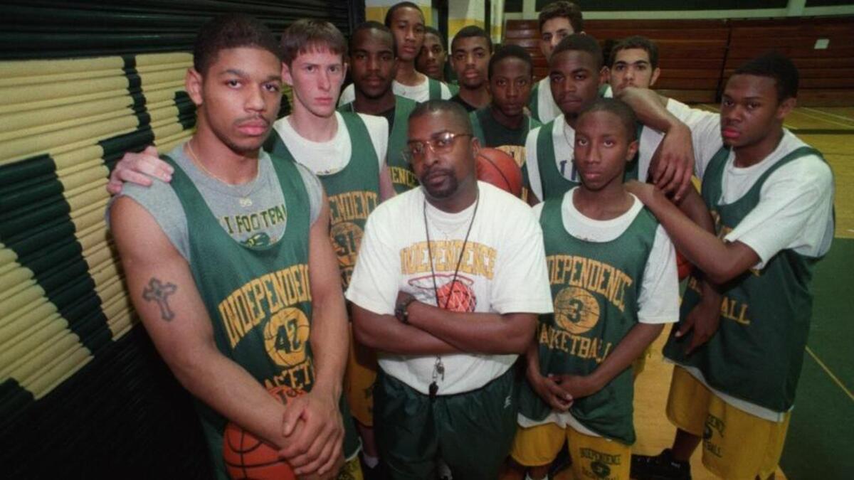 Former Independence High boys’ basketball coach Tony Huggins (center) led the Patriots to the school’s first state championship in 1997.