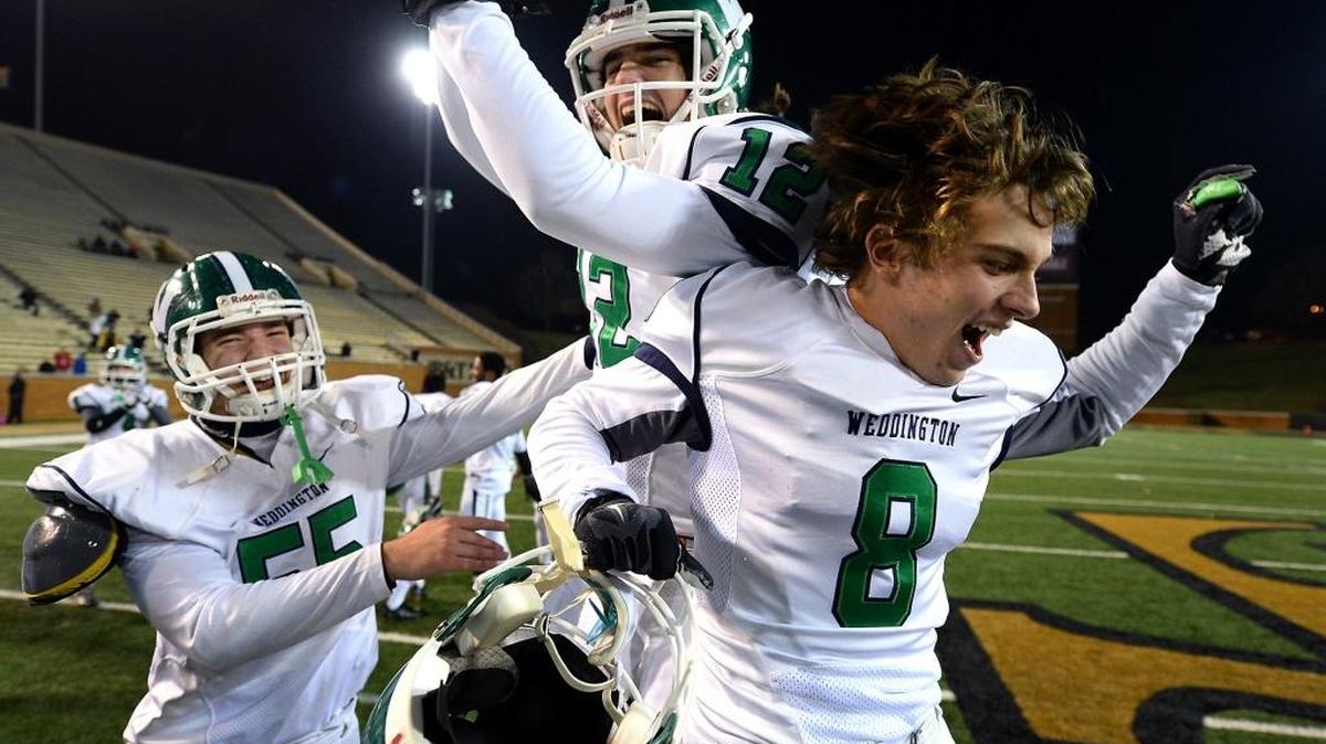 (L-R) Weddington Warriors Christopher Sorensen, Whitner Litton and Branson Mcgee celebrate their team's 33-20 win over Eastern Guilford on Saturday, December 17, 2016 at BB&T Field on the campus of Wake Forest University in Winston-Salem, NC. Weddington defeated Eastern Guilford to win the 3AA Championship.