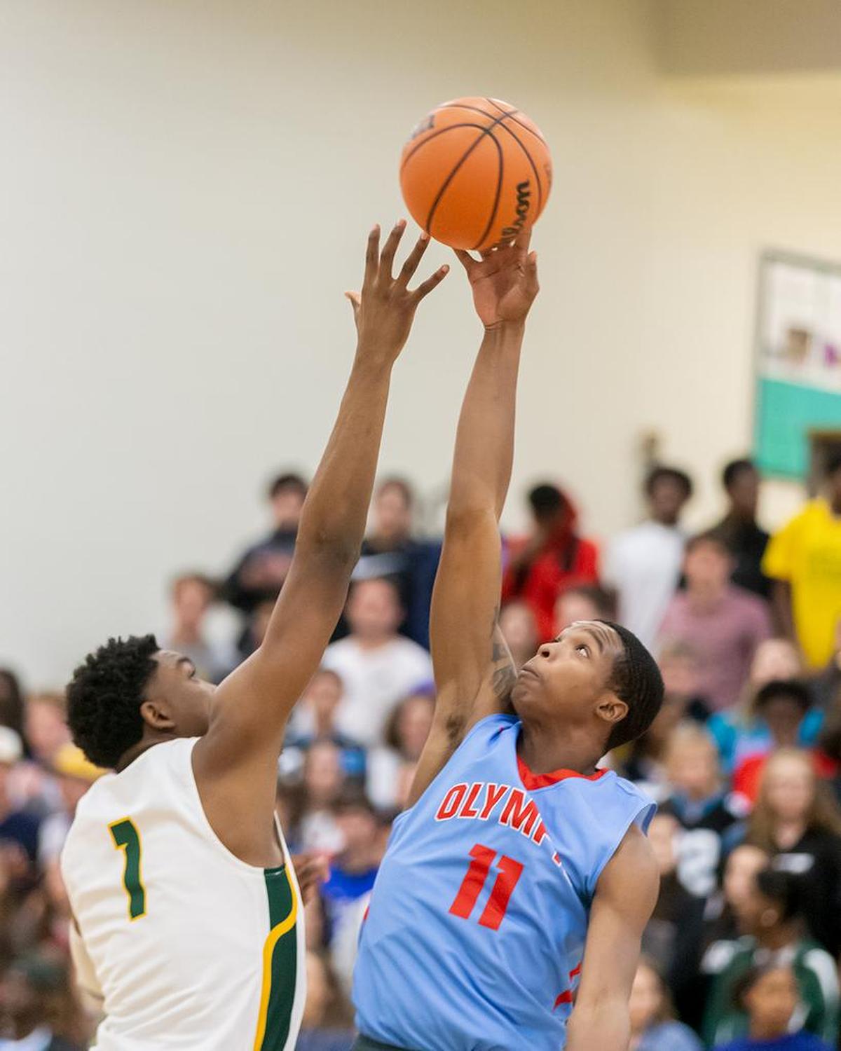 Players jump for the opening tip to start Tuesday’s Olympic at Independence boys game.
