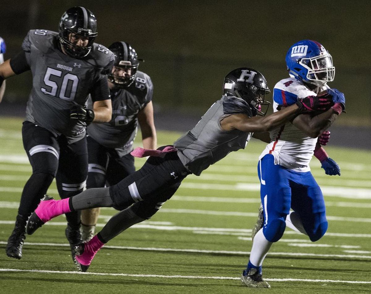 North Meck running back Fabian Duncan, right, tries to get around a Hough defender while facing Hough during a prep football game at Hough High School Friday, October 19, 2018 in Cornelius, NC. Photo by JASON E. MICZEK - Special to the Observer