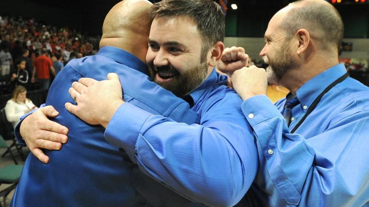 (Center) Lake Norman head coach Brandon Jolly is hugged by his assistant coaches after player Trey Ford (11) hit a game winning three-point basket to defeat Page on Sunday, March 9, 2014 in the Western Regional 4-A Championship at the Greensboro Coliseum Special Events Center in Greensboro, NC. Lake Norman defeated Page 61-58.