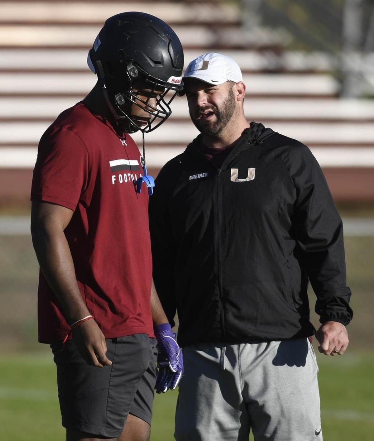 Harding High running back Quavaris Crouch, left, chats with football coach Sam Greiner during practice on Thursday.