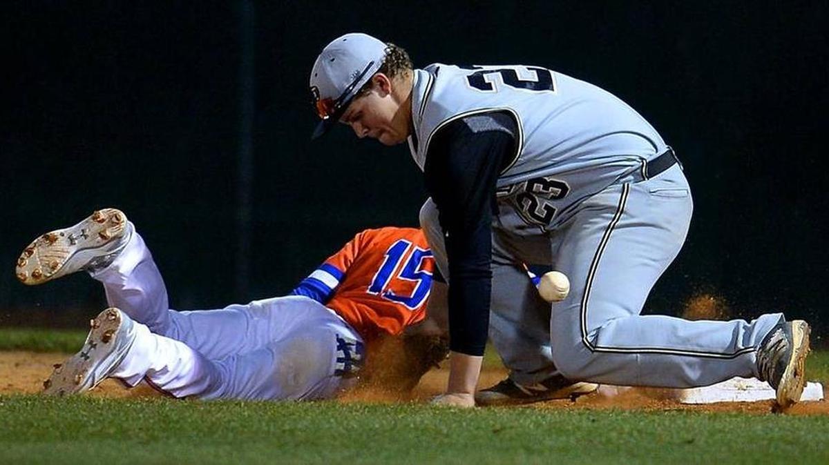 Providence High first baseman Mason Ingle, right, is unable to maintain control of the ball as Marvin Ridge runner Zac Cerreta, left, dives back into first base during prep baseball action on Friday, March 4, 2016 at Marvin Ridge High School. Providence defeated Marvin Ridge 2-0.