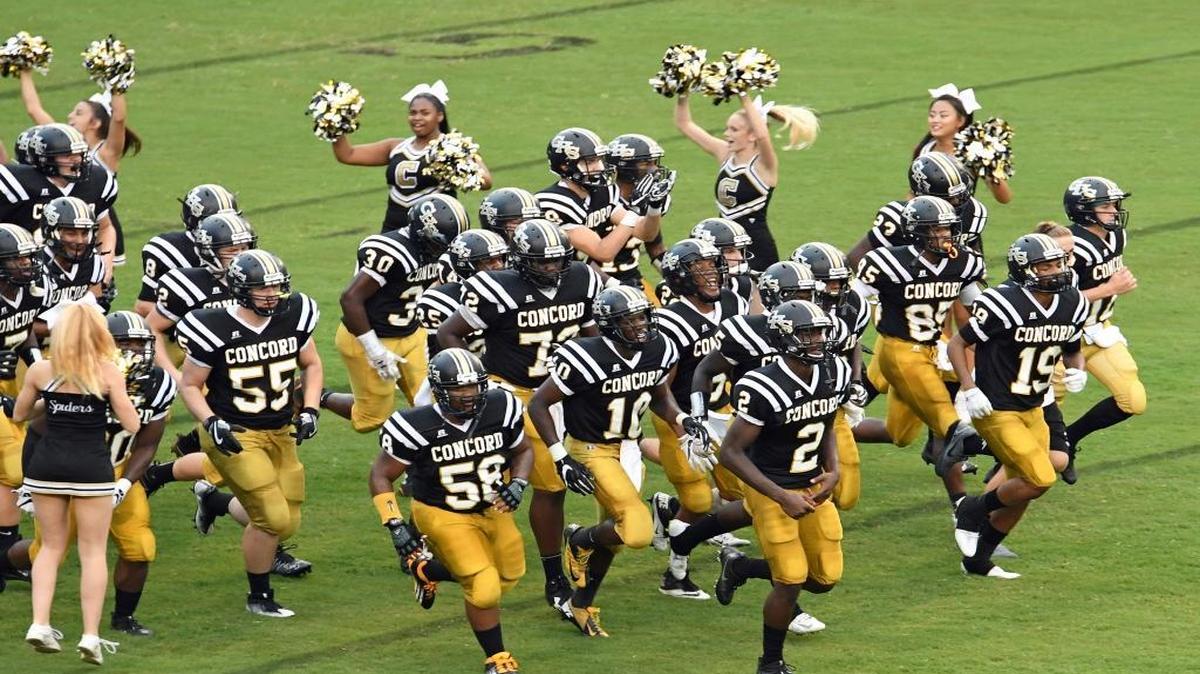 Concord High’s players run onto the field before the start of the 91st Battle for the Bell game against Kannapolis’ A.L. Brown on Aug. 18, 2016 at Robert C. Bailey Stadium in Concord.