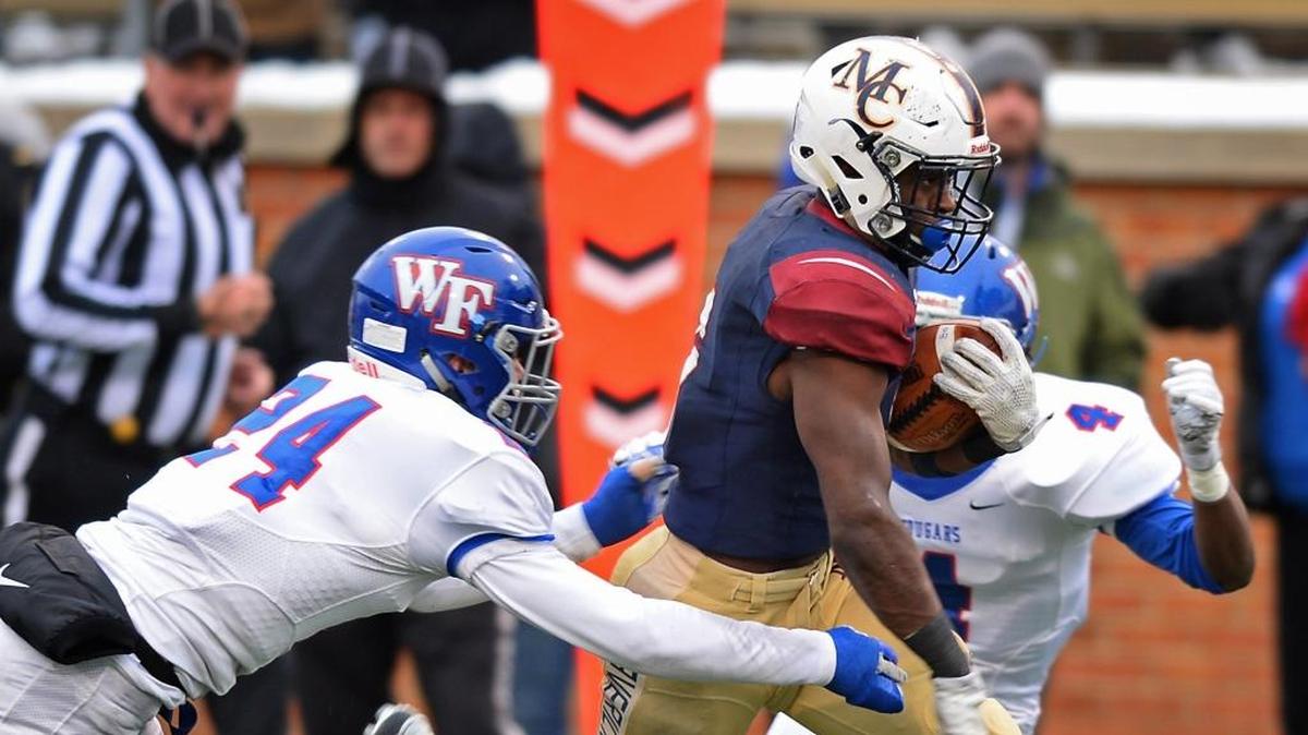 Wake Forest High School free safety Connor Loeffler, left and cornerback Eli Walker, right, work to make the tackle on Mallard Creek running back Nasjzae Bryant, center, during second-quarter action of the NCHSAA 4AA football state championship game at BB&T Field on the campus of Wake Forest University in Winston-Salem on Saturday, Dec. 9, 2017.