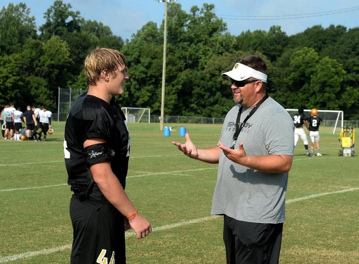 Shelby High LB Dax Hollifield talks with coach Lance Ware at practice.