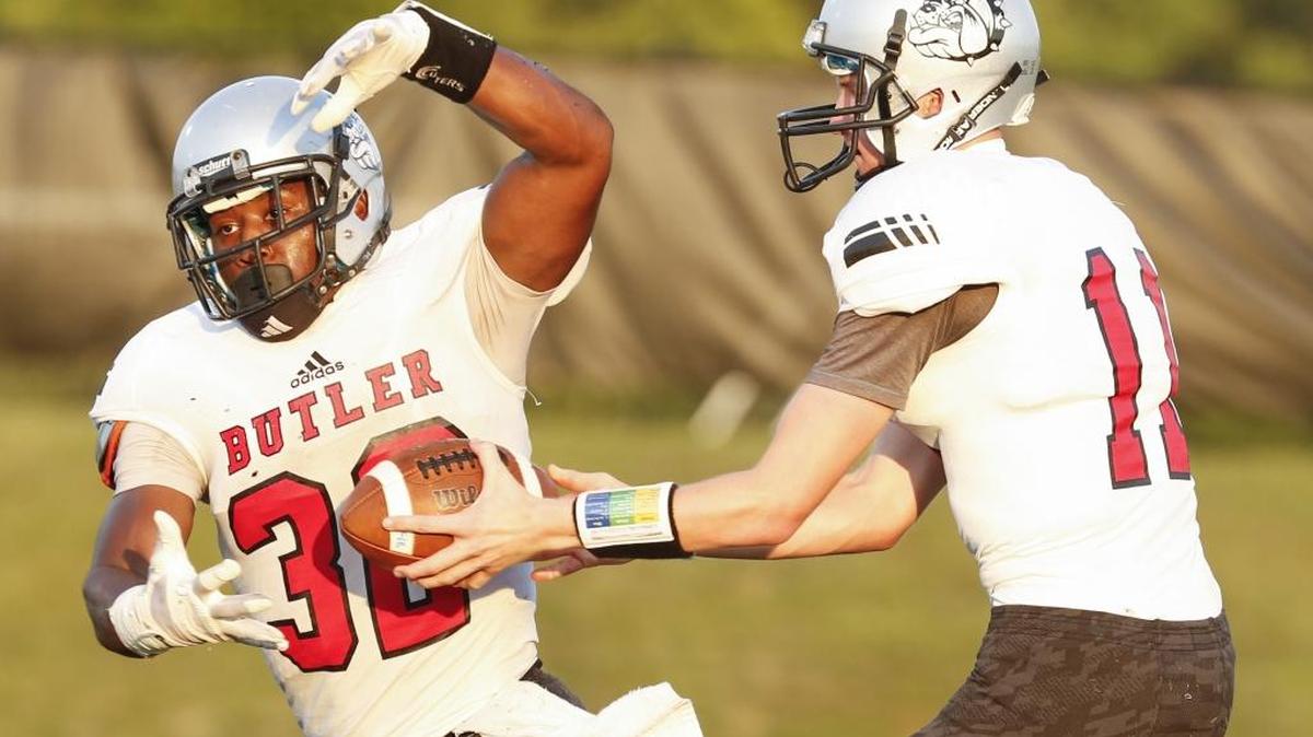 
Butler quarterback Davis Cheek, right, hands the ball off to running back Benjamin Lemay while facing Mallard Creek during an Aug. 28 football game at Mallard Creek High School in Charlotte. 
