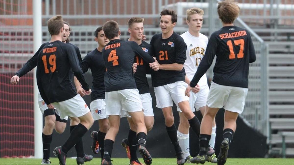 Brandon Young (11) of Marvin Ridge is congratulated by his teammates after scoring the goal. The Chapel Hill Tigers played the Marvin Ridge Mavericks in a men soccer game that counted for the NCHSAA 3A State Championship and took place at the N.C. State University Dail Stadium in Raleigh, N.C. on Saturday, November 19, 2016. Marvin Ridge won 1-0.