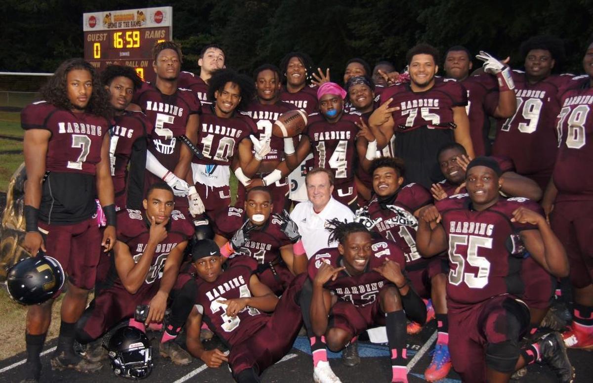 Harding High’s football team surrounds volunteer team photographer Chip Case, a local orthodonist who began chronicling the team last summer.