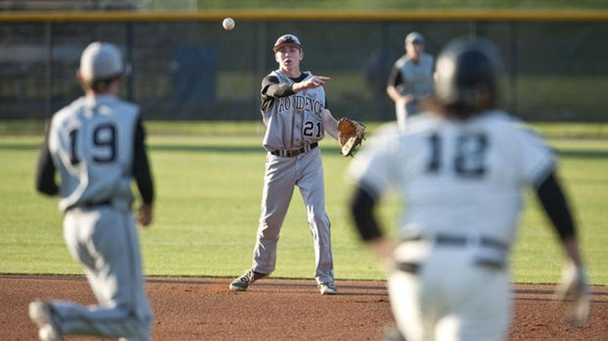 Zach Brown of Providence (center) fields a ball hit by North Davidson’s Cole Beeker (right) and throws to first as Providence pitcher Tim Townsend (left) covers during a game Tuesday.