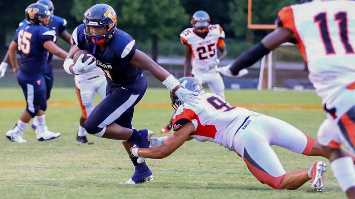 Rocky River’s Jaylon Sharpe (9) makes an open-field tackle on Nigel Summerville (left) during early first-quarter action against host Vance.