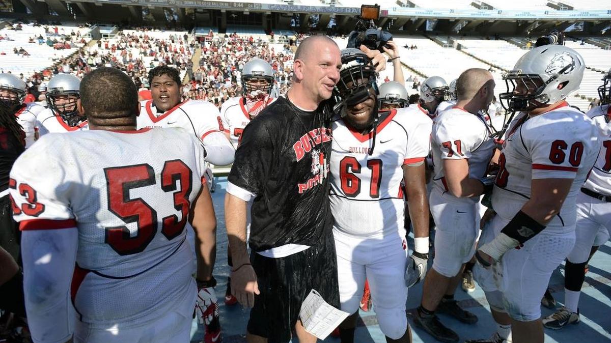 In 2012, Butler football coach Brian Hales hugs Jacobie Gore (61) as as his team celebrated a 56-28 win in the state championship game. Saturday, three Mecklenburg County teams play for titles: Mallard Creek, Harding and Charlotte Catholic.