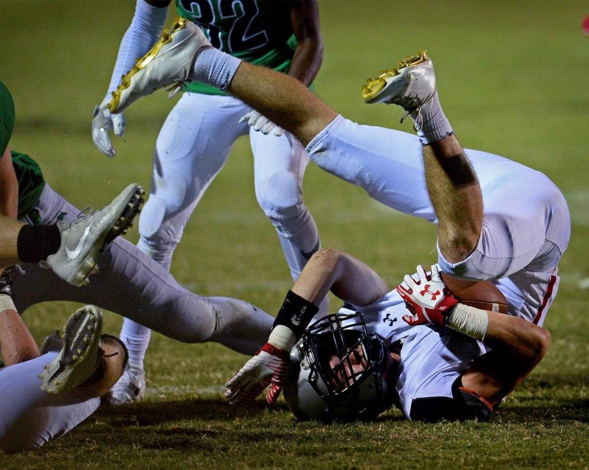 Butler’s T.J. Cusick , recovering a fumble above, and fellow Bulldog defensive backs Damel Hickman and Keyon Lesane shut down host Myers Park passing attack in Friday’s 28-7 win.