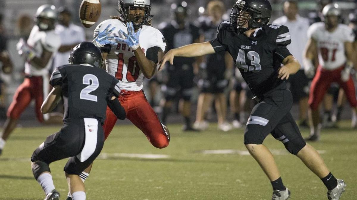 Butler receiver Kusegi Cureton (10) can’t get a handle on a pass while being defended by Hough’s Will Fording (2) and Michael Amado (43) during Friday night’s game at Hough.
