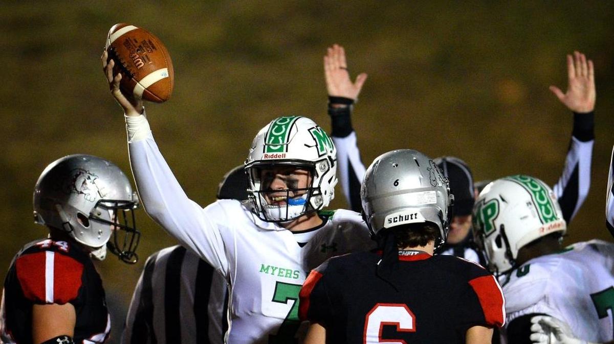 Myers Park Mustangs quarterback Brayden Hawkins holds the ball in the air and smiles after scoring the winning touchdown against the Butler Bulldogs during fourth quarter action on Friday, November 17, 2017 at Butler High School. Myers Park defeated Butler 28-24.