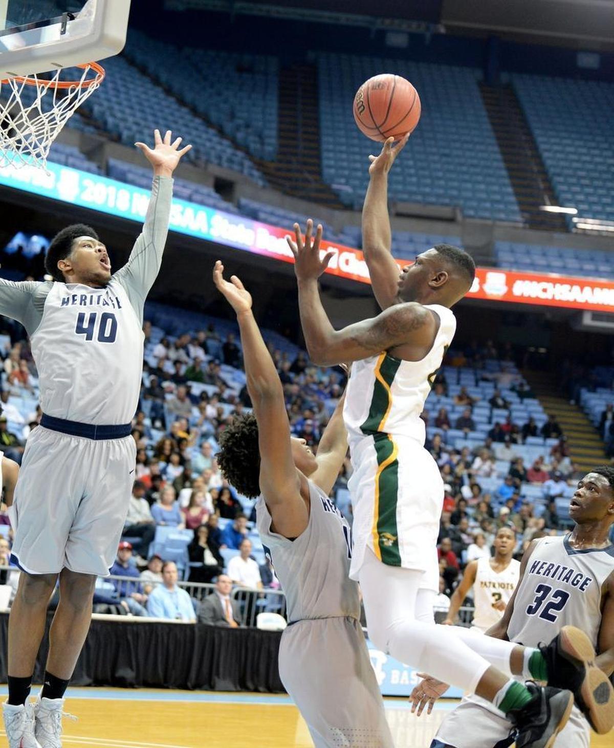Independence # 2 Jamarius Burton shoots against Heritage #40 Jayden Gardner during Saturday evening's NCHSAA state basketball championship 4A game between Independence and Wake Forest Heritage at the Smith Center in Chapel Hill.