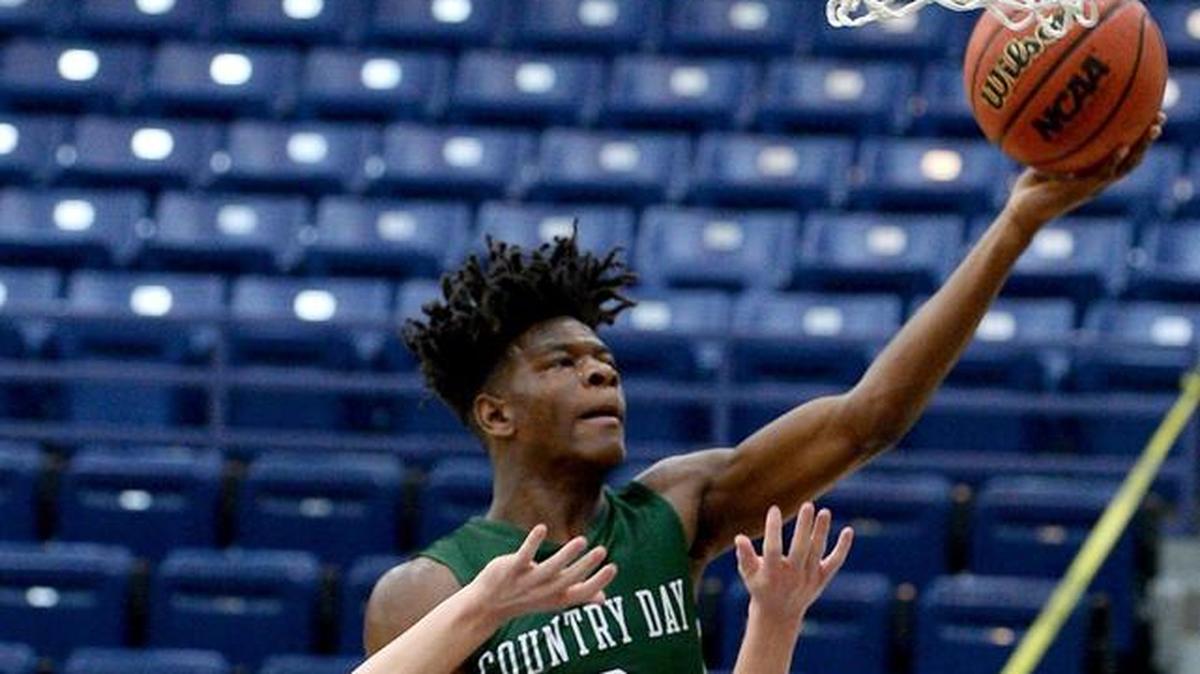 Charlotte Country Day School's DeAngelo Epps, center, drives down the lane for two-points over Charlotte Latin defender William Lloyd, left, during first half action on Monday, January 22, 2018 at Charlotte Latin School.