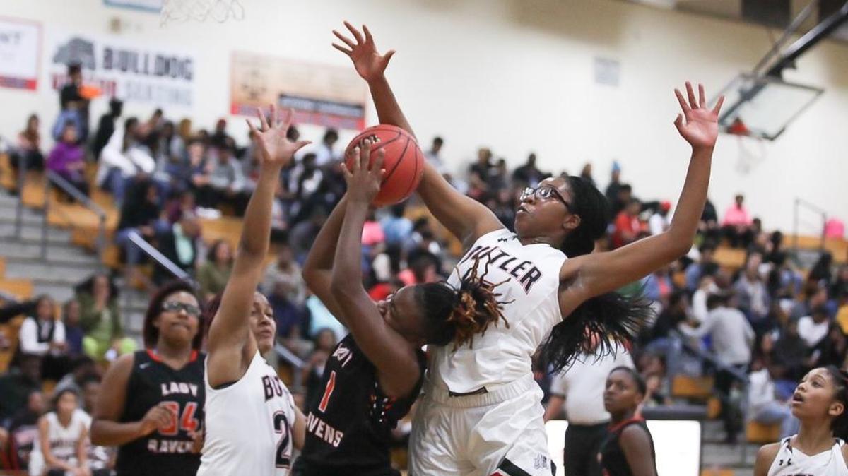 Butler's Michaela Lane (center) goes up for the block against Rock River's Alexander Andresia during Tuesday's night's game against Rocky River