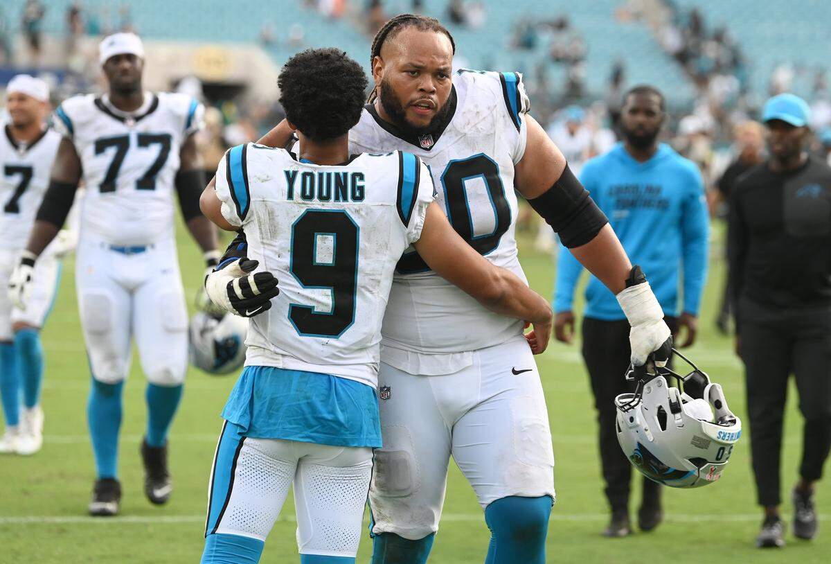 Carolina Panthers quarterback Bryce Young and guard Robert Hunt, right, embrace following the team’s 26-10 loss to the Jacksonville Jaguars on Sunday, Sept. 7, 2025, at Everbank Stadium in Jacksonville, Florida.