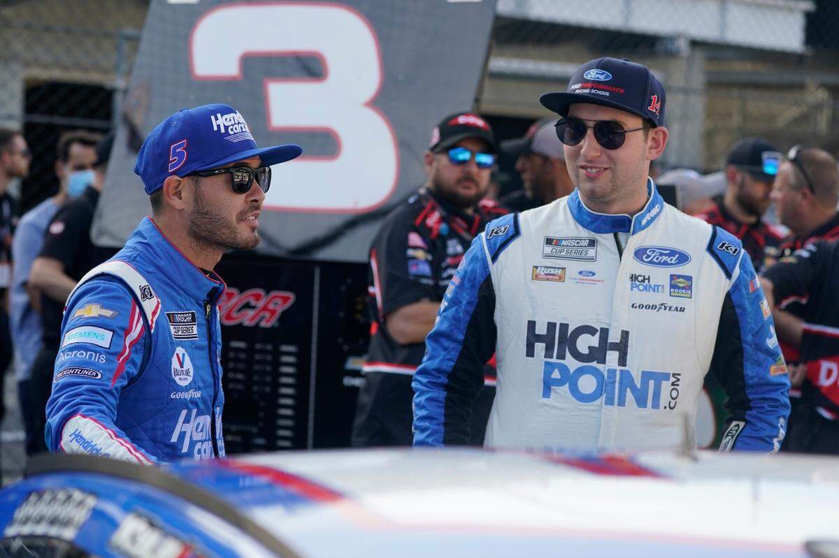 Kyle Larson, left, talks with Chase Briscoe before qualifications for the NASCAR Series auto race at Indianapolis Motor Speedway, Sunday, Aug. 15, 2021, in Indianapolis. (AP Photo/Darron Cummings)