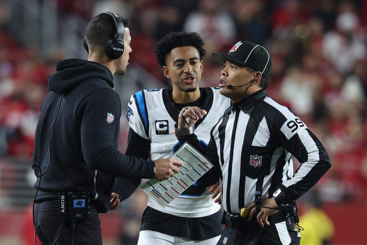 Head coach Dave Canales of the Carolina Panthers and quarterback Bryce Young speak with side judge Lo van Pham in the second quarter of Monday’s game against the San Francisco 49ers at Levi's Stadium.