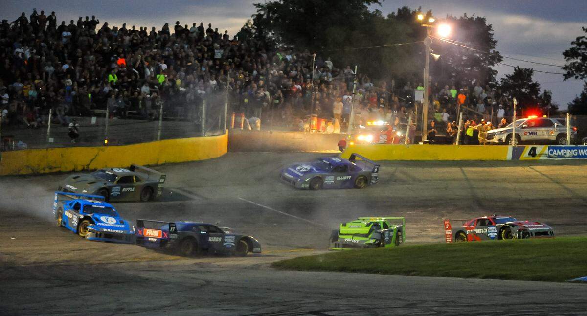 Cars scatter bringing out a caution on the white flag lap of the feature at the Superstar Racing Experience event Saturday, July 10, 2021, at Slinger Speedway in Slinger, Wisconsin.