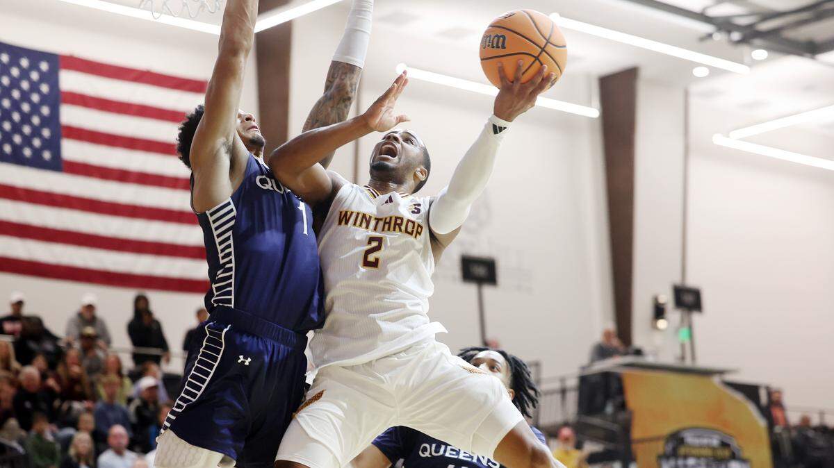 Winthrop University's Kareem Rozier (2) puts up the shot as Queens University's Jordan Watford tries to block it Monday at the Rock Hill Sports and Event Center. Winthrop won, 81-74, in a game that tipped off at 8 a.m.
