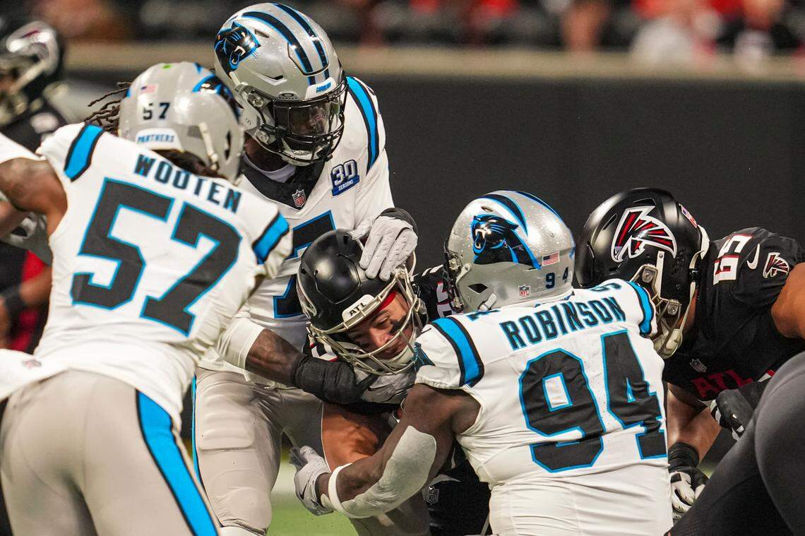 Jan 5, 2025; Atlanta, Georgia, USA; Atlanta Falcons running back Tyler Allgeier (25) is tackled by Carolina Panthers linebacker Jadeveon Clowney (7) and defensive end A’Shawn Robinson (94) during the first quarter at Mercedes-Benz Stadium. Mandatory Credit: Dale Zanine-Imagn Images