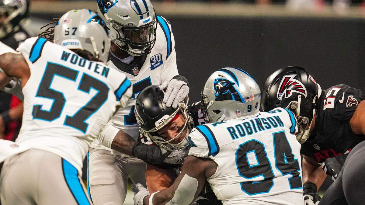 Jan 5, 2025; Atlanta, Georgia, USA; Atlanta Falcons running back Tyler Allgeier (25) is tackled by Carolina Panthers linebacker Jadeveon Clowney (7) and defensive end A’Shawn Robinson (94) during the first quarter at Mercedes-Benz Stadium. Mandatory Credit: Dale Zanine-Imagn Images